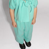 4 year old girl standing wearing a matching top and pants in teal denim polka dot